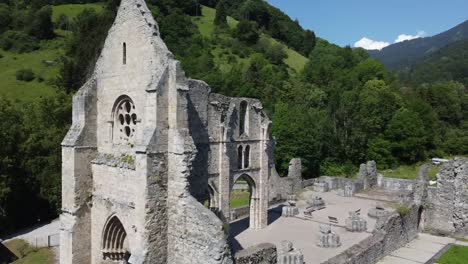 an arc shot of old church ruins taken by a drone in the french alps