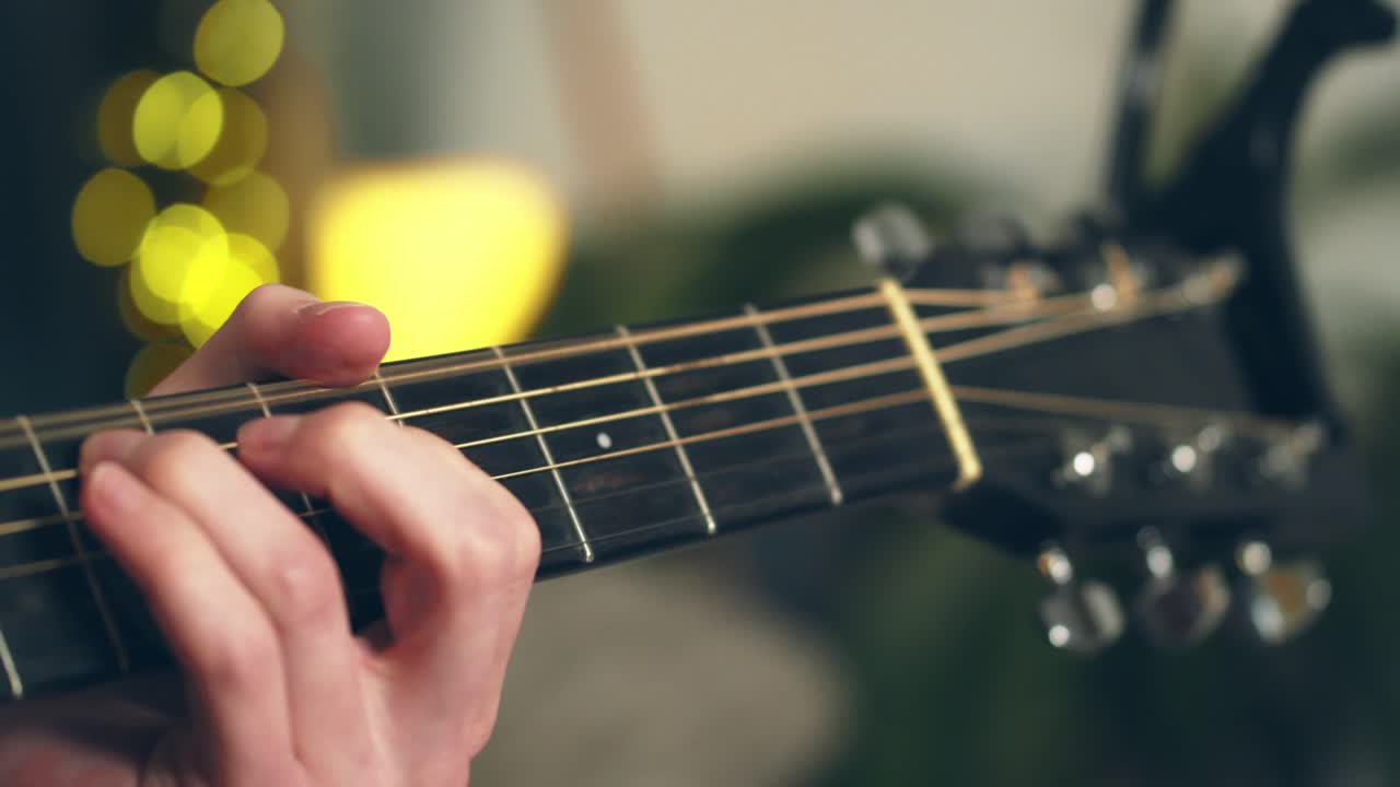 Young Man Playing Guitar in front of beautiful lighted background