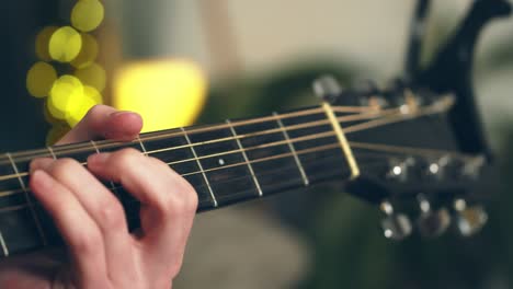 joven tocando la guitarra frente a un hermoso fondo iluminado