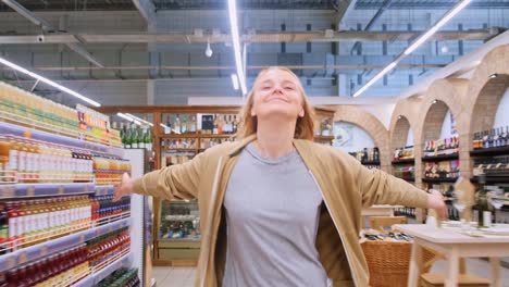 a joyful moment: woman embracing freedom in a vibrant store while spreading her arms wide with happiness amid shelves of bottled goods