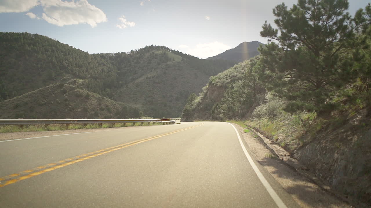 un chico skater bombardeando una colina empinada en el interior de colorado en una patineta