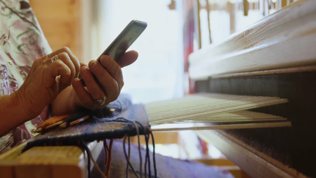 Halvprofil af ældre hvid kvinde, der arbejder på en tablet på et værksted 4k