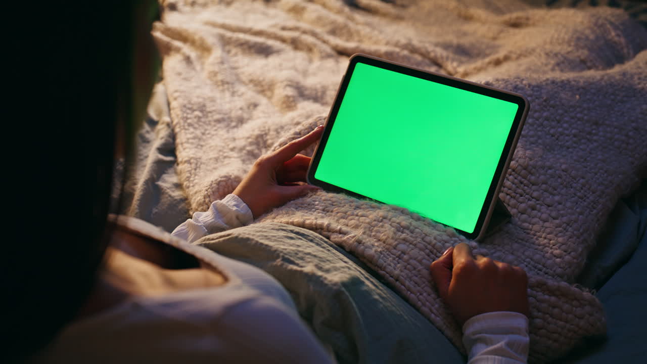 Freelancer hand scrolling chroma key tablet lying bed closeup. Remote worker