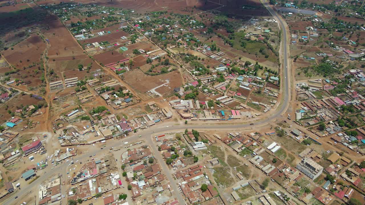 Vista aerea di una città e campi illuminati dal sole, ora d'oro nell'Africa rurale - ripresa in tracking con drone