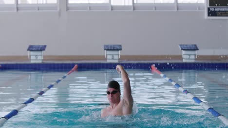 swimmer coming out of the water and raising arm