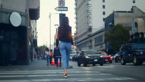 Unrecognized-woman-walking-on-crossroad-big-city.-Unknown-girl-crossing-road.