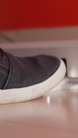 toma de primer plano de un pie con un zapato negro y pantalones vaqueros azules pisando gradualmente un pedal de piano, capturando el detalle de la interacción entre el pie del músico y el instrumento