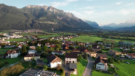 vista aérea de liechtenstein con casas en campos verdes en el valle de las montañas de los alpes