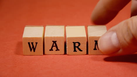 Composing-the-word-Warm-with-wooden-letters-on-a-red-background