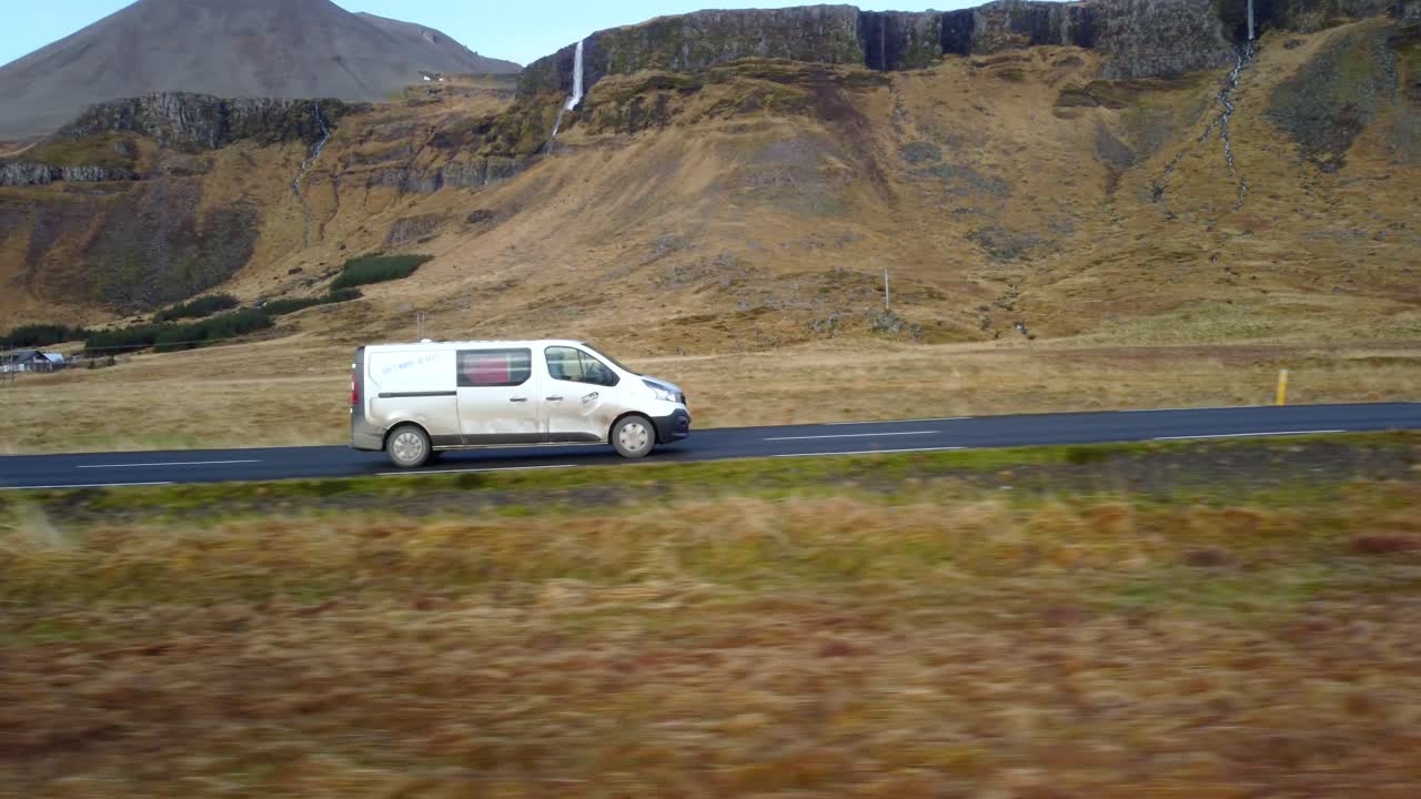 Un'auto percorre una strada panoramica in Islanda