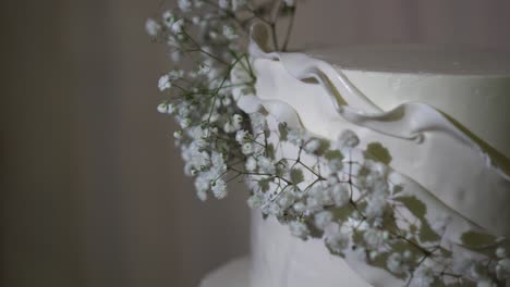 Wedding-cake-made-of-white-fondant,-decorated-with-small-natural-flowers