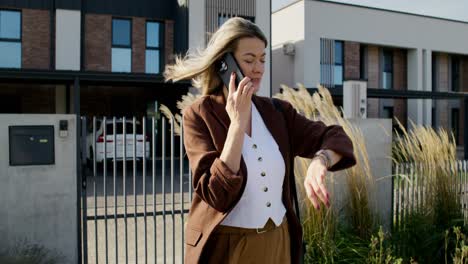 woman talking on phone outside modern homes