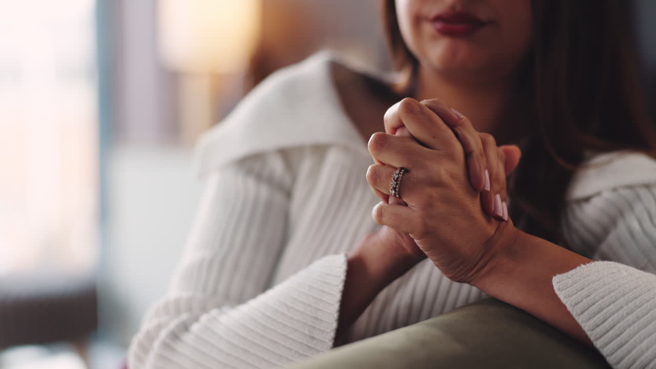A woman with her hands clasped