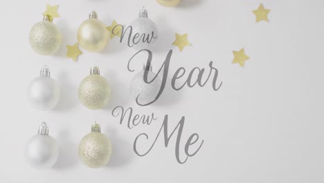 animation of new year new me text over christmas baubles