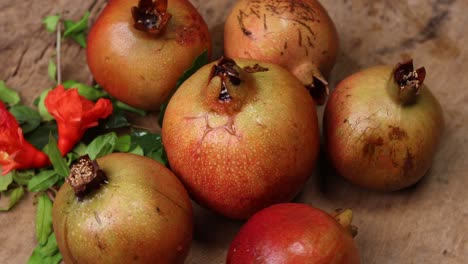 ripe pomegranate with leaves on a wooden board on a dark background