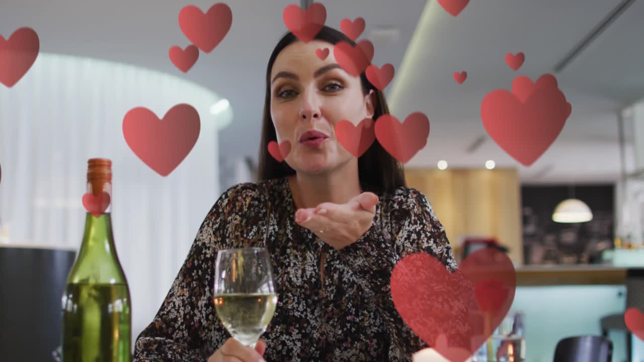 백인 여성이 와인을 마시고 비디오 통화를 하는 것에 대한 심장의 애니메이션