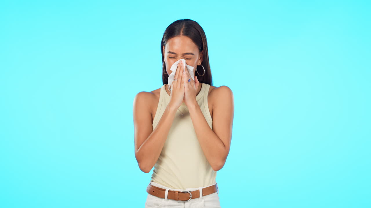 tejido, soplar la nariz y la mujer aislada en un azul