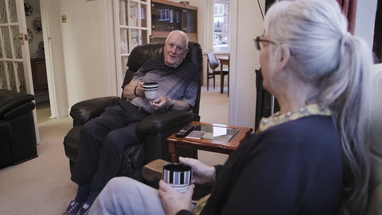 Elderly couple enjoying tea and conversation in their living room