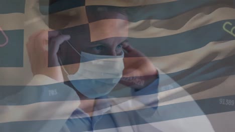 Animation-of-numbers-and-greece-flag-over-caucasian-male-doctor-in-face-mask