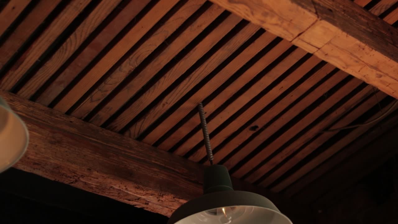 Old lamp hanging from a wooden ceiling, establisher
