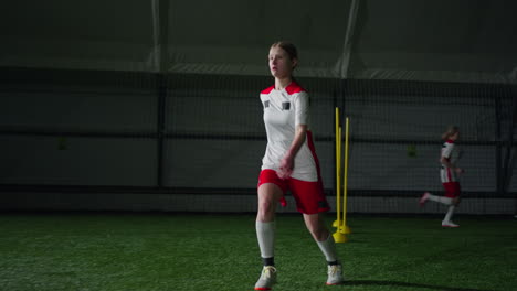 young woman practicing soccer dribbling