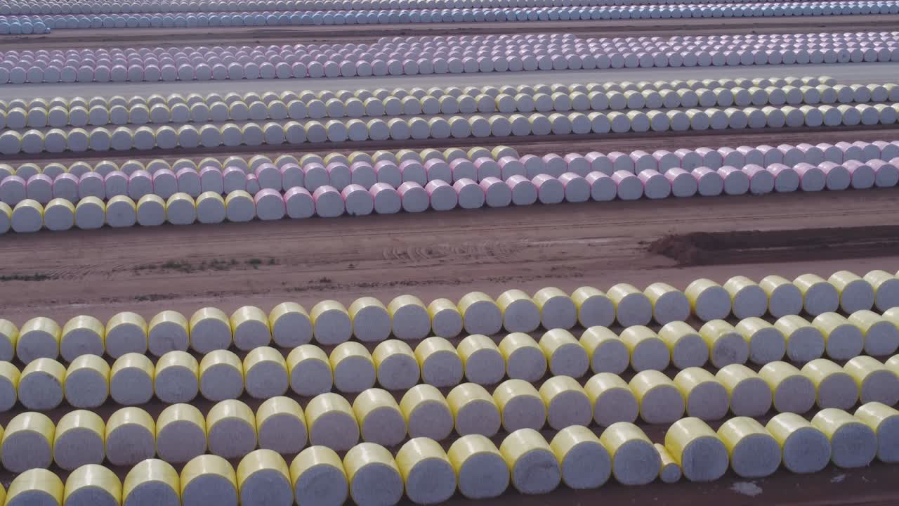 un clip aéreo ascendente de filas de balas de algodón para ser procesadas por una máquina de cortar algodón