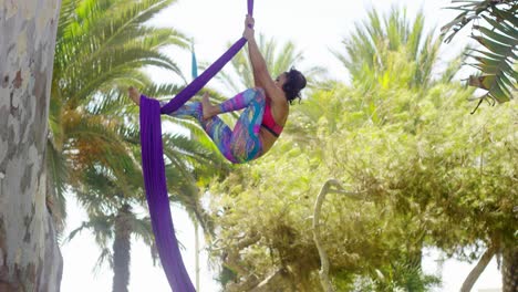 Female-acrobat-working-outdoors-on-silk-ribbons