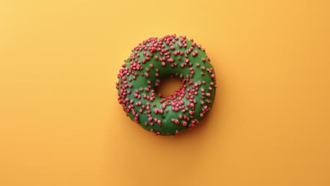 top view appetizing fresh tasty doughnut covered by green icing and pastry topping rotating