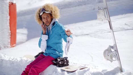 mujer riendo hablando en su móvil en la nieve