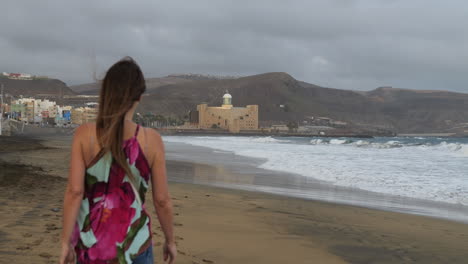 Fantástico-Plano-Cinematográfico-Al-Amanecer-De-Una-Mujer-Paseando-Por-La-Playa-De-Las-Canteras-Y-Al-Fondo-Se-Puede-Ver-El-Auditorio-Alfredo-Kraus