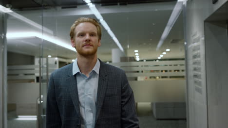 smiling businessman walking in office lobby. guy going for work