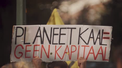 green environmental protesters hold signs netherlands hague government building