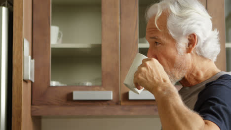 senior man having coffee in kitchen 4k