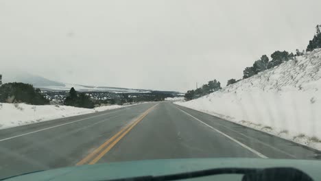 vista interior de un automóvil que circula por una carretera en un paisaje frío y nevado