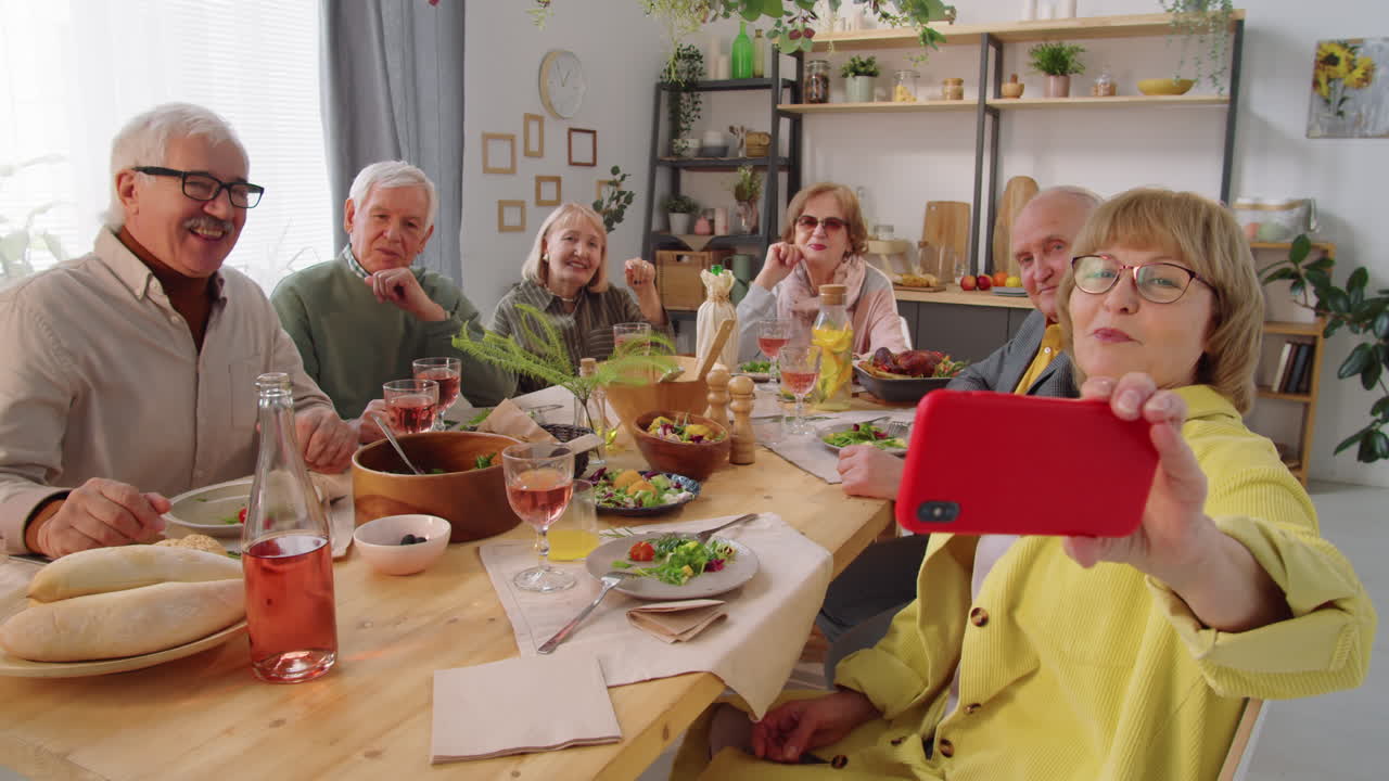 Elderly Friends Taking Selfie at Dinner Table