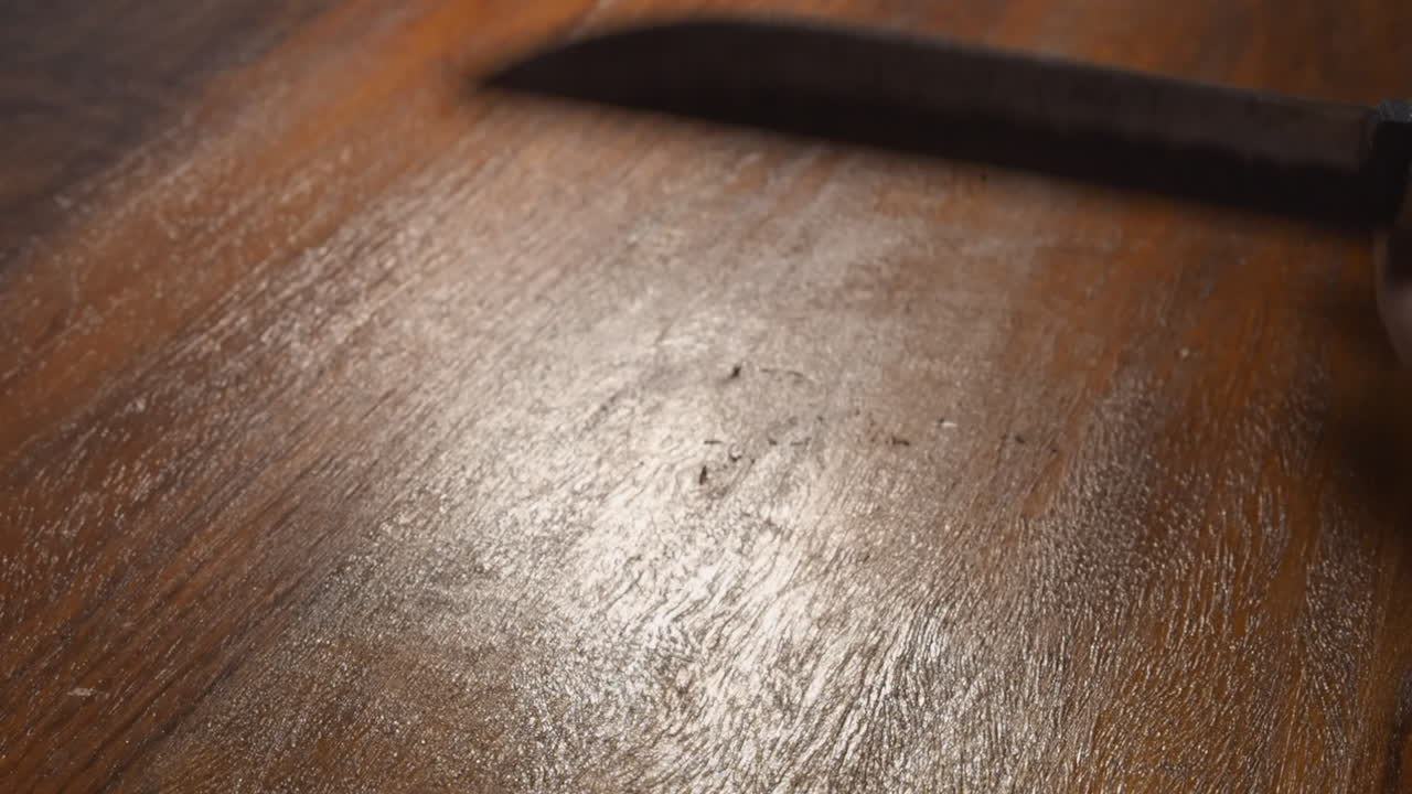 burras removidas del borde forjado de un cuchillo de caza con una piedra de afilar, primer plano