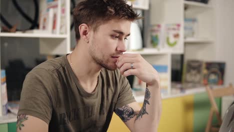 Attractive-sexy-programmer-with-tattooes-on-his-arms-thinking-hard-about-something.