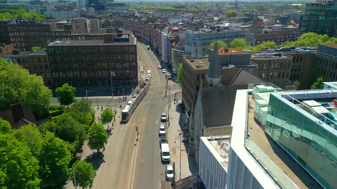 Advancing aerial video of the Luas Tram System operating in Dublin City Centre, County Leinster, Ireland, on a bright and sunny day. Filmed in 4K, 60FPS and with Rec709 color.