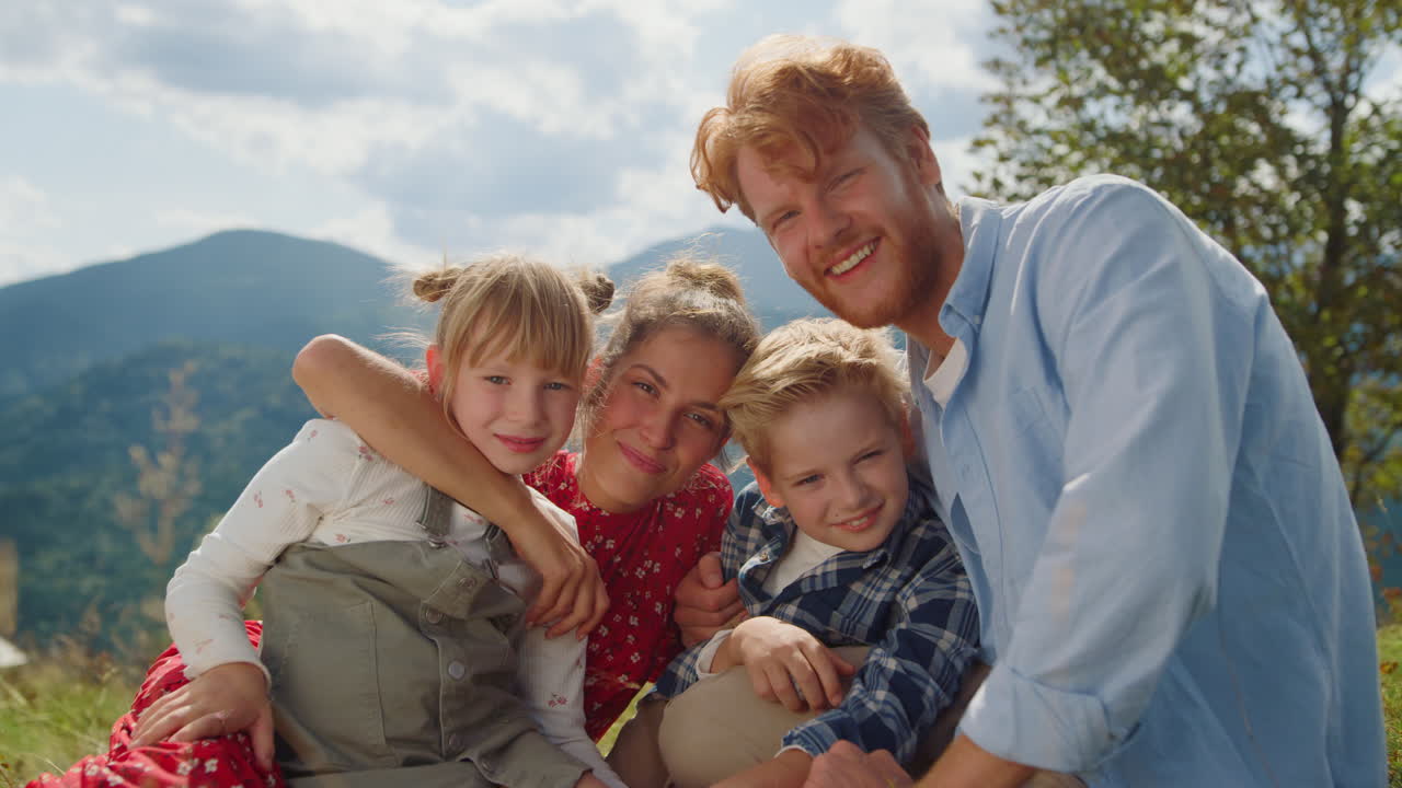 Happy parents posing children sitting meadow sunny day closeup. Family holiday.