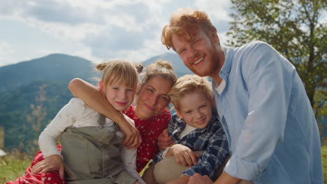 Glückliche-Eltern-Posieren-Kinder-Sitzend-Auf-Der-Wiese,-Sonniger-Tag,-Nahaufnahme.-Familienurlaub.