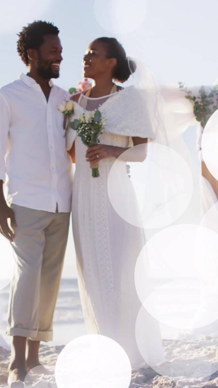 Animation of dots over happy african american newly married couple on beach