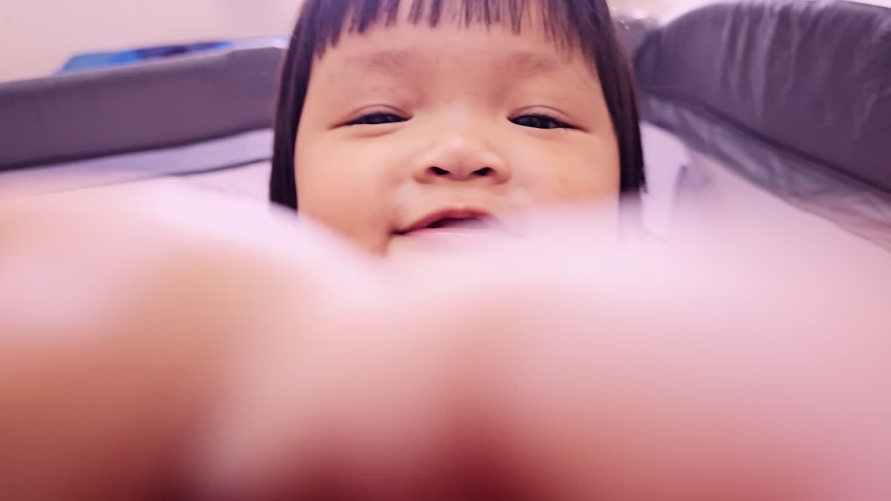 A cute baby smiles joyfully at the camera capturing a delightful moment in a cozy home environment.