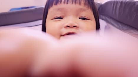 a cute baby smiles joyfully at the camera capturing a delightful moment in a cozy home environment.
