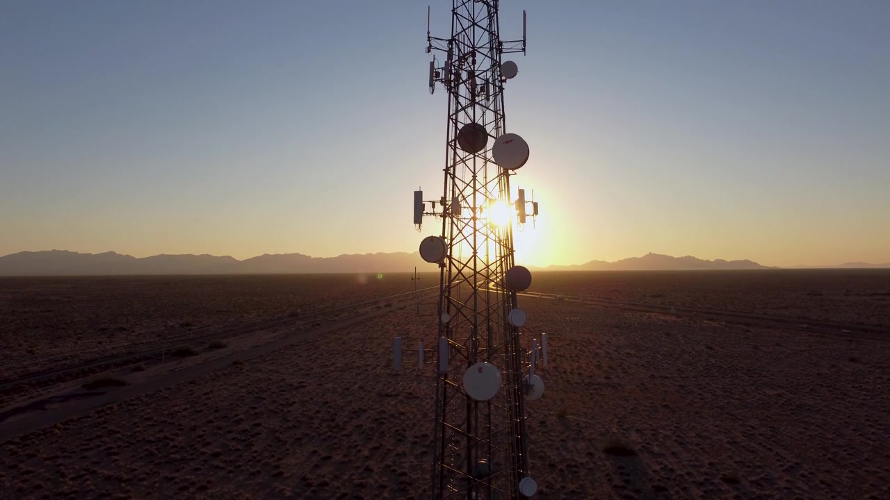 Aerea: Torre cellulare al tramonto nel deserto dell'Arizona. In ascesa verso la cima della torre.