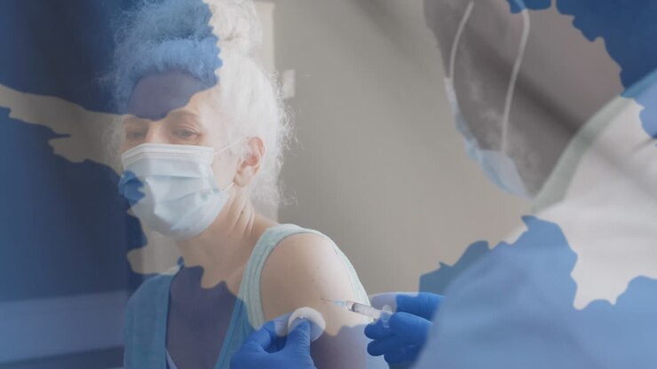 Animation of flag of antarctica and senior woman wearing face mask being vaccinated