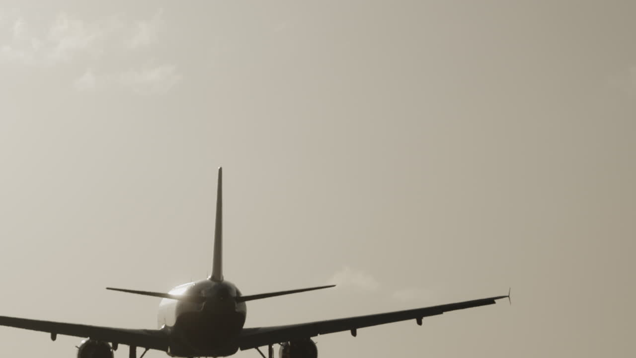 Avión volando en el cielo para aterrizar en el aeropuerto a cámara superlenta al atardecer