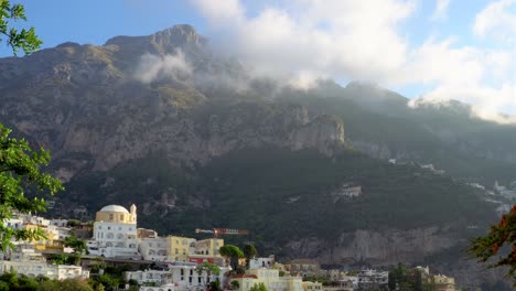 Clouds-passing-over-the-vertical-town-of-Positano,-embedded-in-the-steep-Lattari-Mountains-of-Italy,-time-lapse