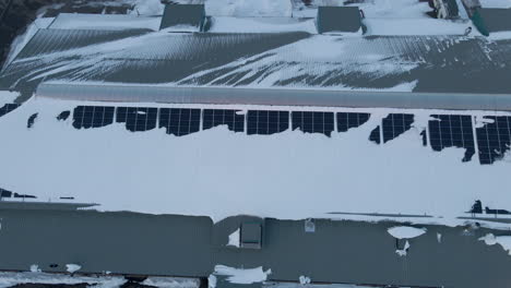 plataforma rodante aérea de paneles solares cubiertos de nieve en la azotea del almacén