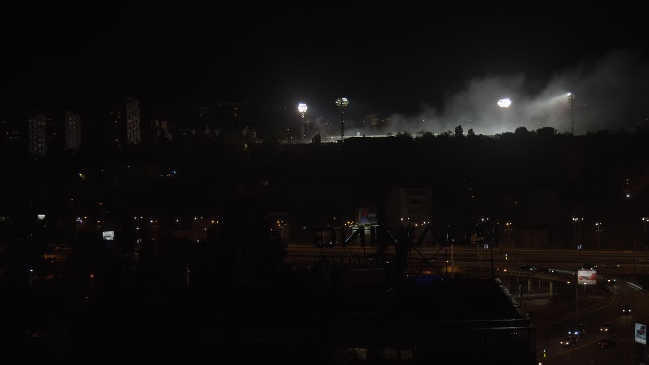 Night View of a City with Stadium Lights Illuminating Haze