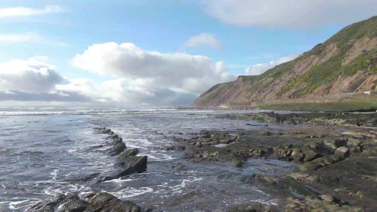 Rocce oceaniche frastagliate, ripresa con drone verso le montagne